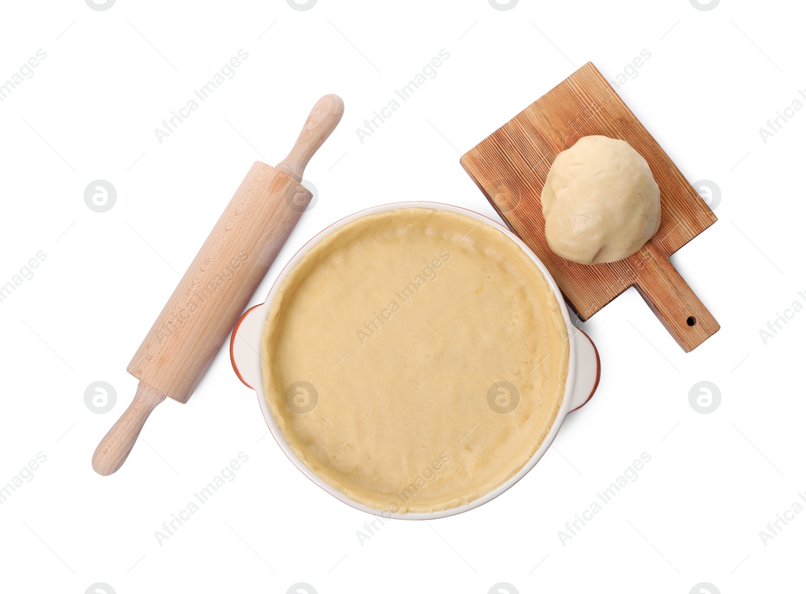 Photo of Pie tin with fresh dough and rolling pin isolated on white, top view. Making quiche