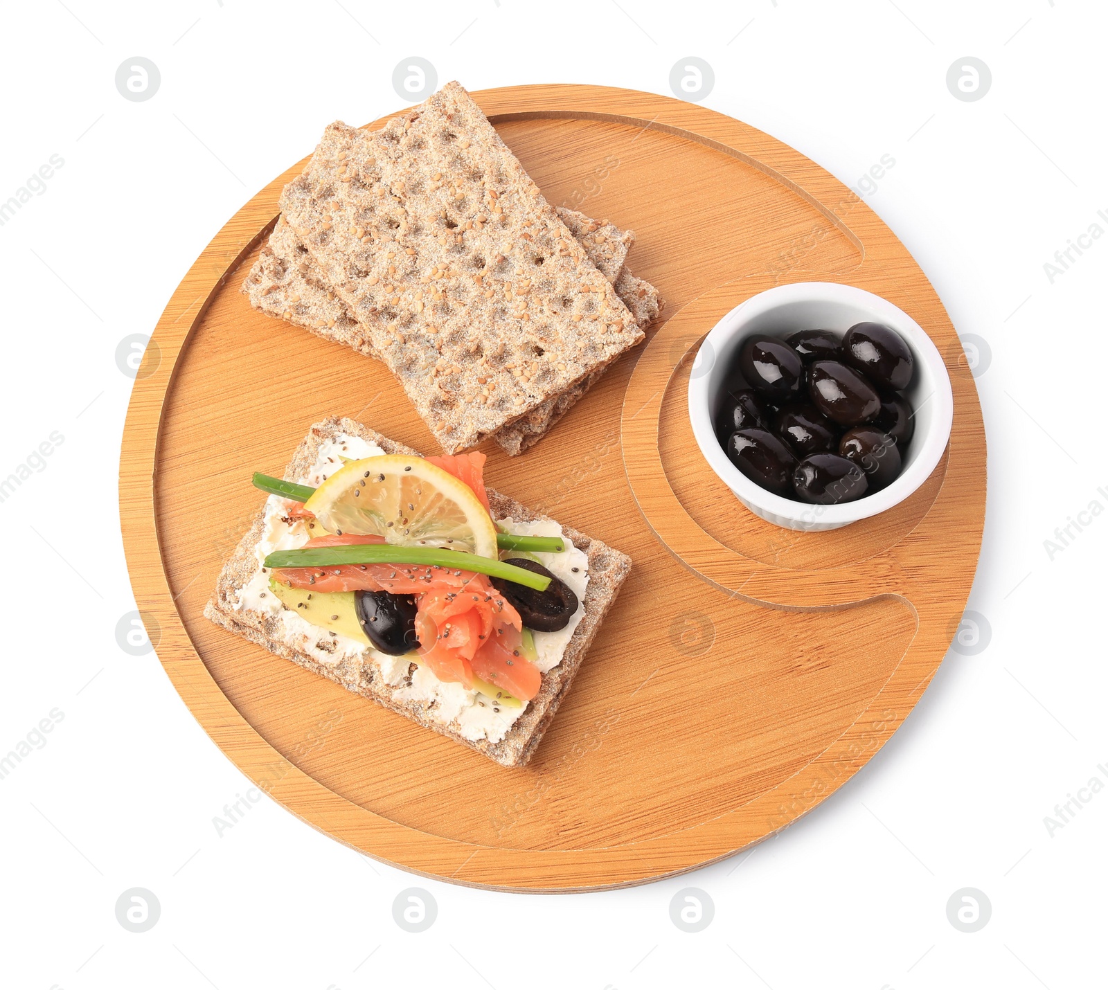 Photo of Fresh crunchy crispbreads with cream cheese, salmon, olives, lemon and green onion on white background, above view