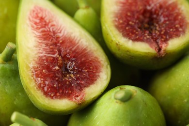 Photo of Cut and whole fresh green figs as background, closeup view