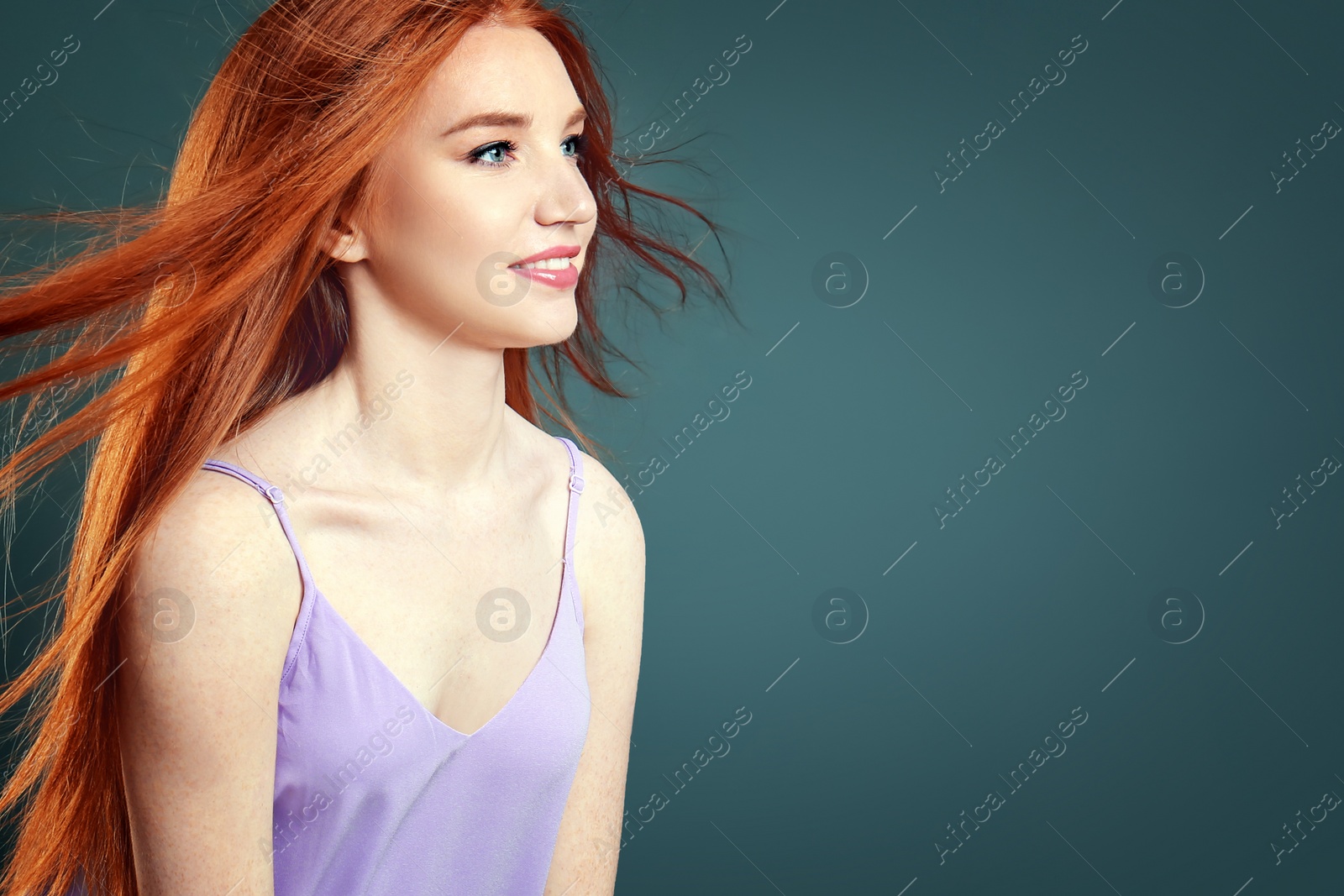 Photo of Portrait of young model with beautiful  hair on grey background