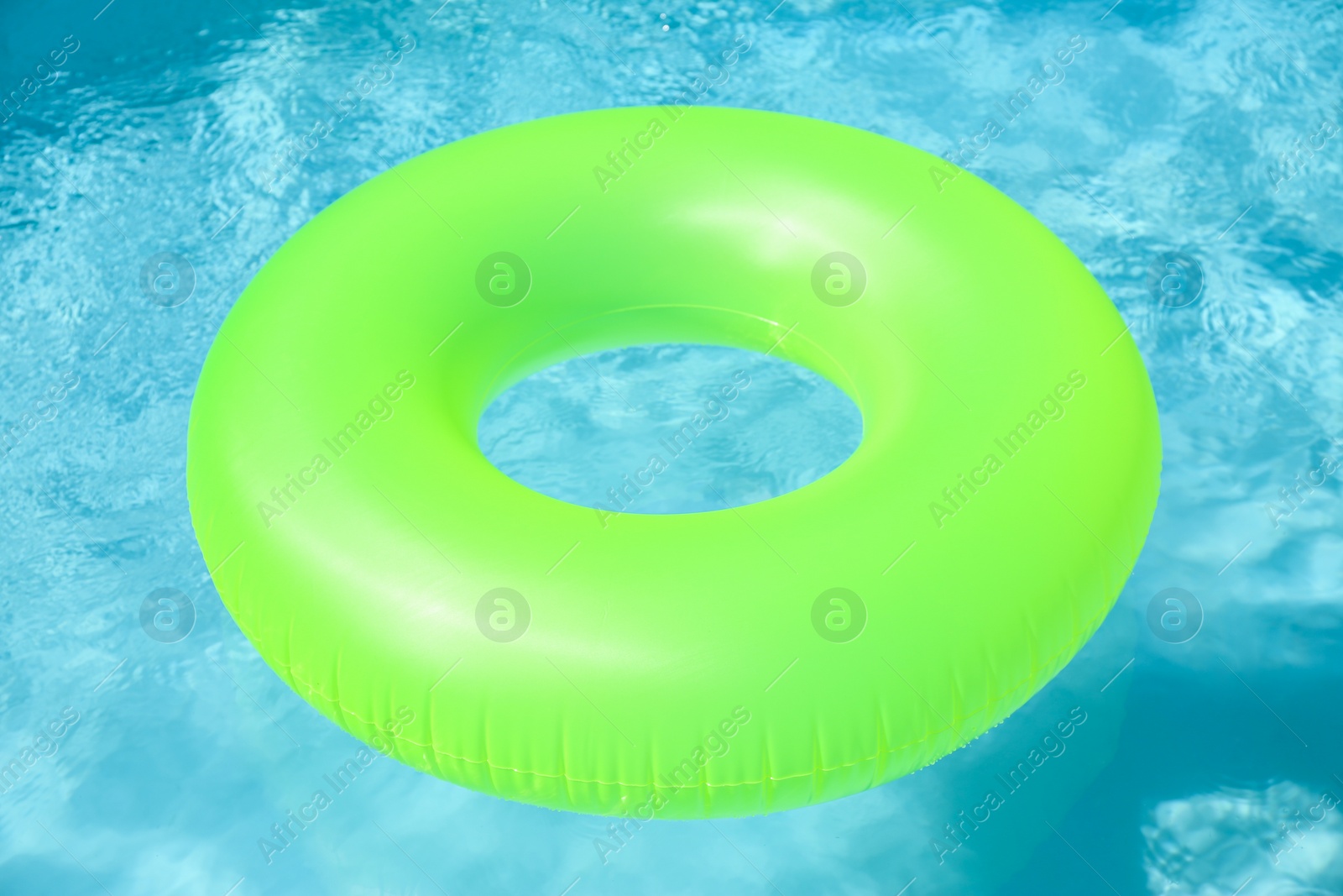 Photo of Bright inflatable ring floating in swimming pool on sunny day