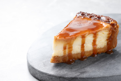 Piece of delicious cake with caramel on light table. Space for text