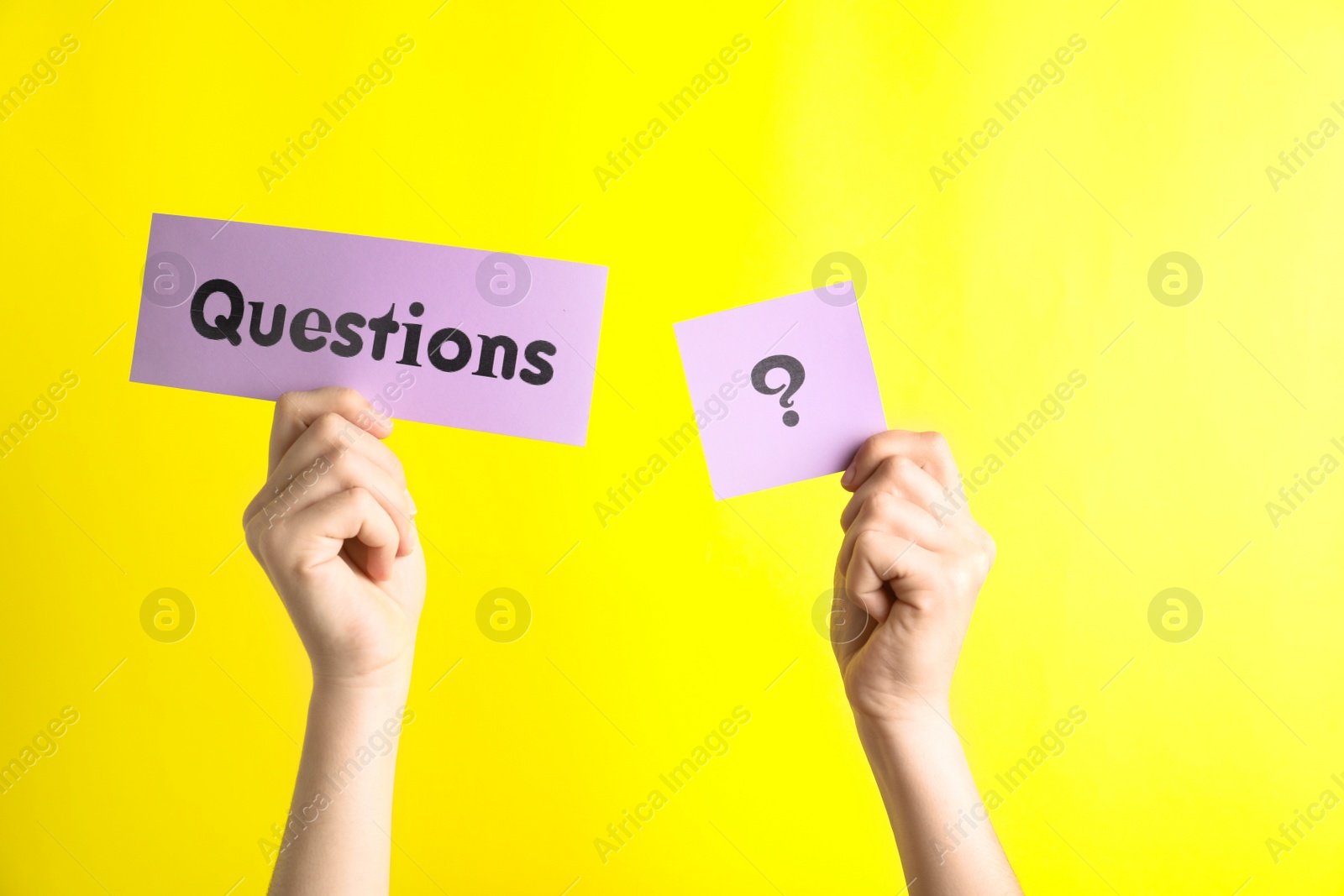 Photo of Woman holding sheets of paper with word QUESTIONS and query mark on yellow background, closeup