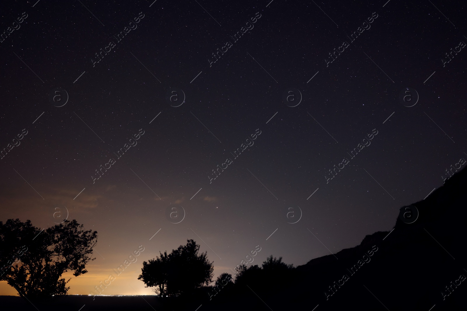 Photo of Picturesque view of starry sky at night over hill