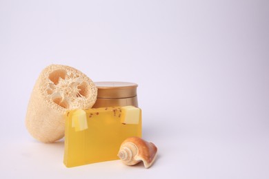 Photo of Natural loofah sponge, cosmetic products and seashell on white background