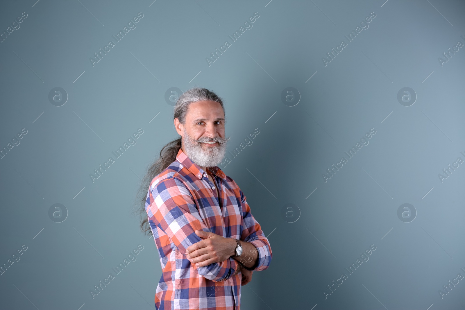 Photo of Handsome bearded mature man on color background