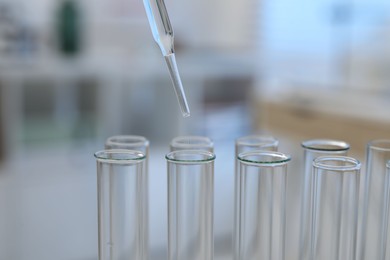 Photo of Laboratory analysis. Dripping liquid into test tubes indoors, closeup