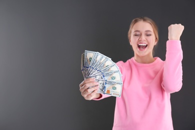 Photo of Portrait of emotional young woman with money on grey background. Space for text