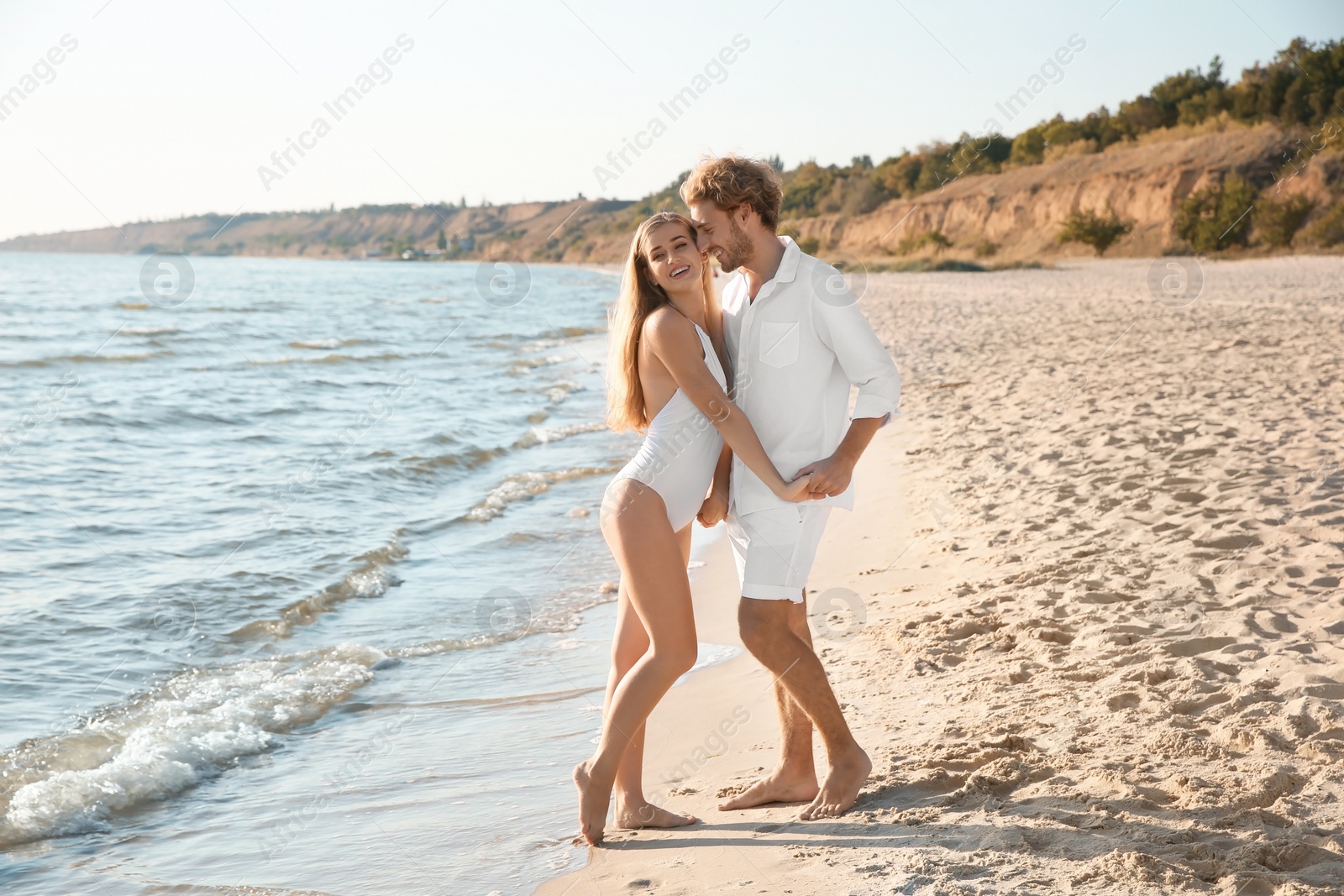 Photo of Romantic young couple spending time together on beach