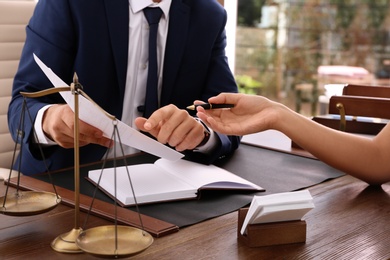 Photo of Lawyer working with client at table in office, focus on hands