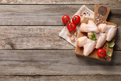 Photo of Raw chicken wings and ingredients on wooden table, flat lay. Space for text