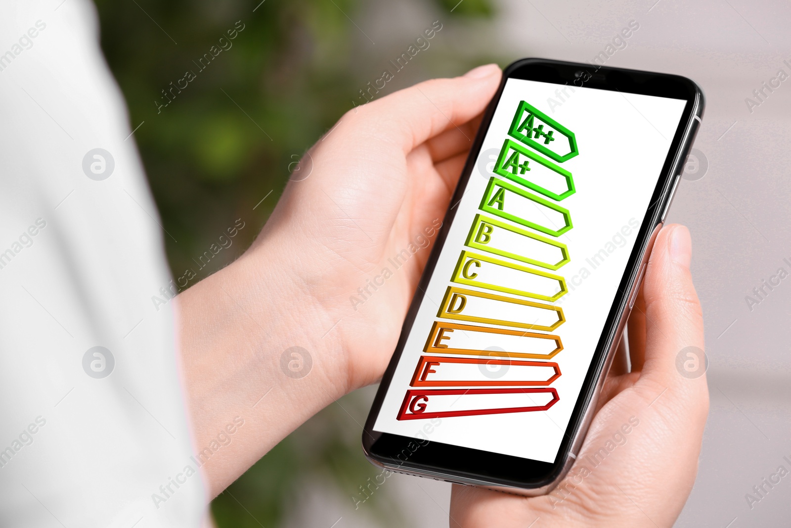 Image of Energy efficiency. Woman using smartphone with colorful rating on display indoors, closeup
