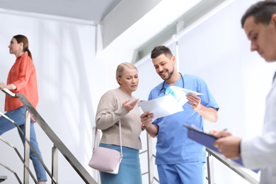 Photo of Doctor and patient discussing diagnosis on stairs in hospital