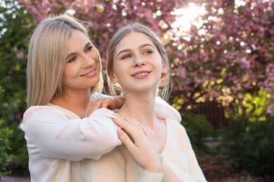 Photo of Happy mother with her daughter spending time together in park on sunny day