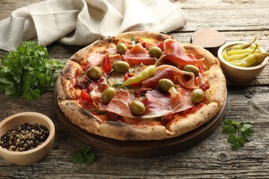 Photo of Tasty pizza and ingredients on wooden table