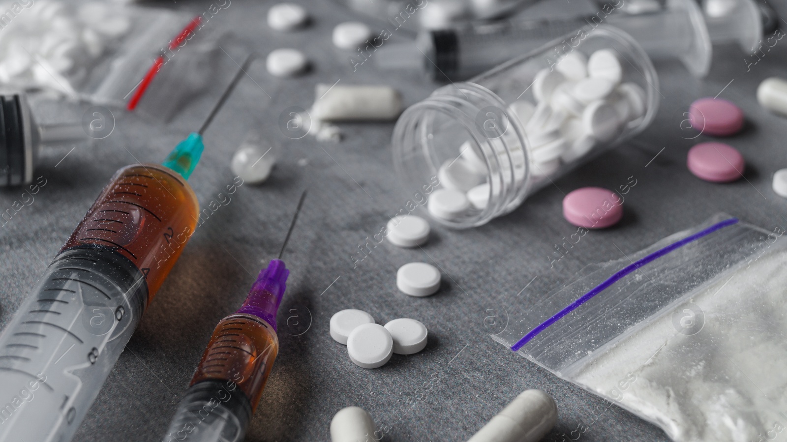 Photo of Different hard drugs on grey table, closeup