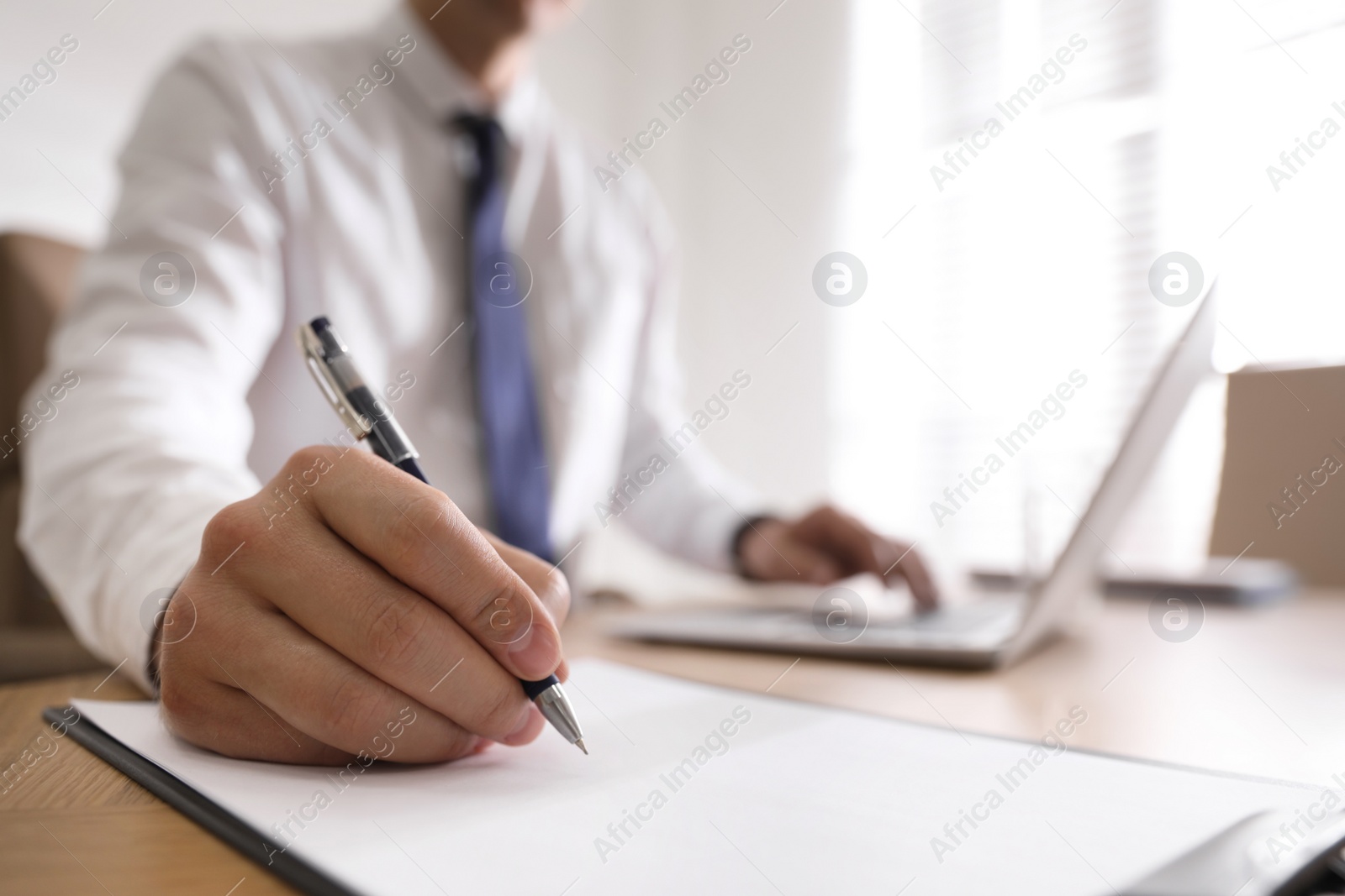 Photo of Man working at table in office, closeup of hand