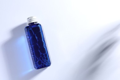 Bottle of cosmetic product on white background, top view. Space for text