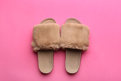 Photo of Pair of soft slippers on pink background, flat lay