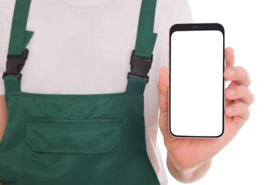 Professional repairman in uniform with phone on white background, closeup