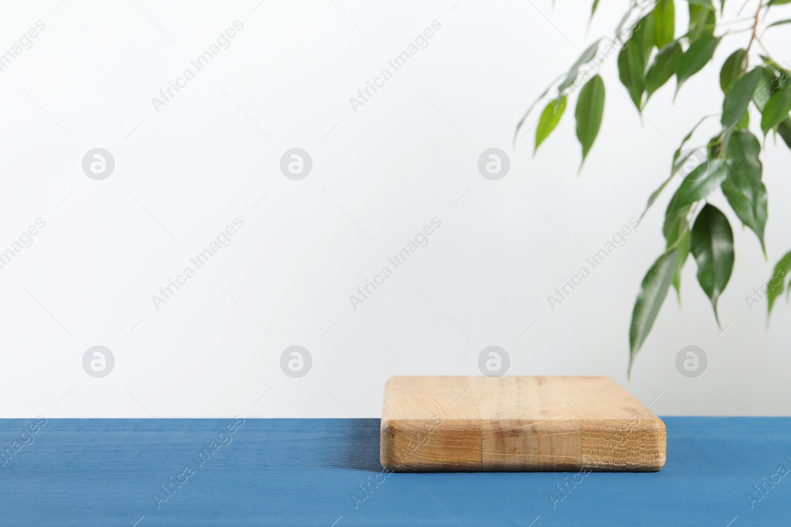 Photo of Board on blue wooden table. Space for text