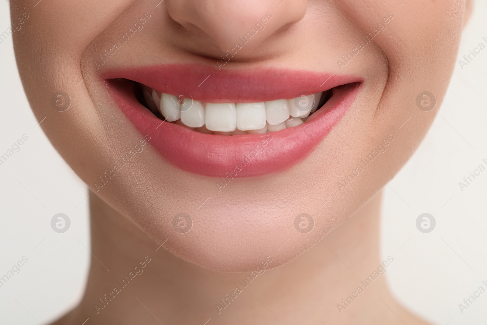 Photo of Young woman with beautiful smile on white background, closeup