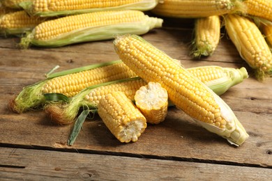 Photo of Tasty sweet corn cobs on wooden table