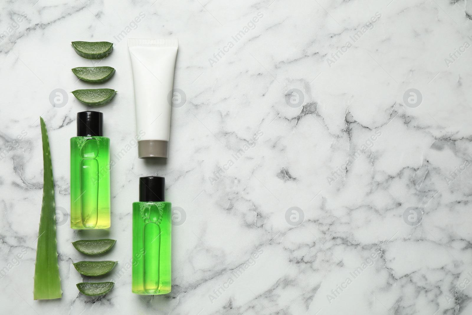 Photo of Flat lay composition with aloe vera and cosmetic products on white marble background. Space for text