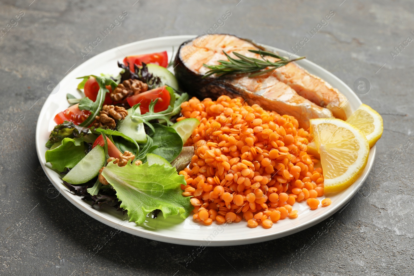 Photo of Plate with healthy food high in vegetable fats on grey textured table, closeup