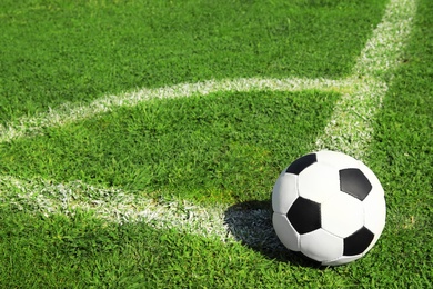 Photo of Soccer ball on fresh green football field grass. Space for text