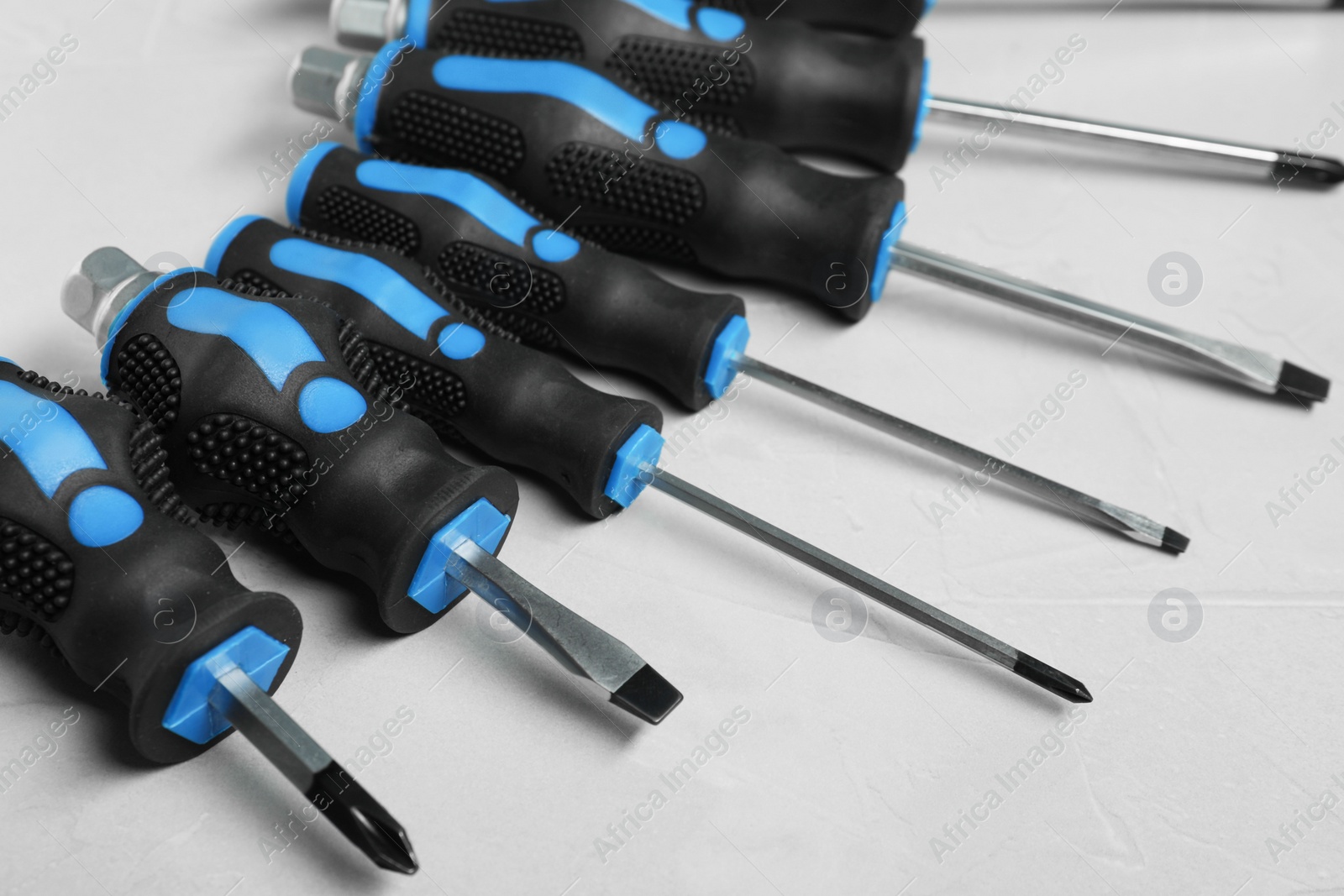 Photo of Set of screwdrivers on light grey background, closeup