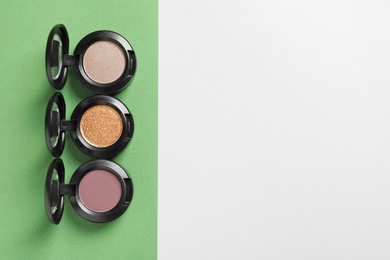 Photo of Flat lay composition with different eye shadows on color background. Space for text