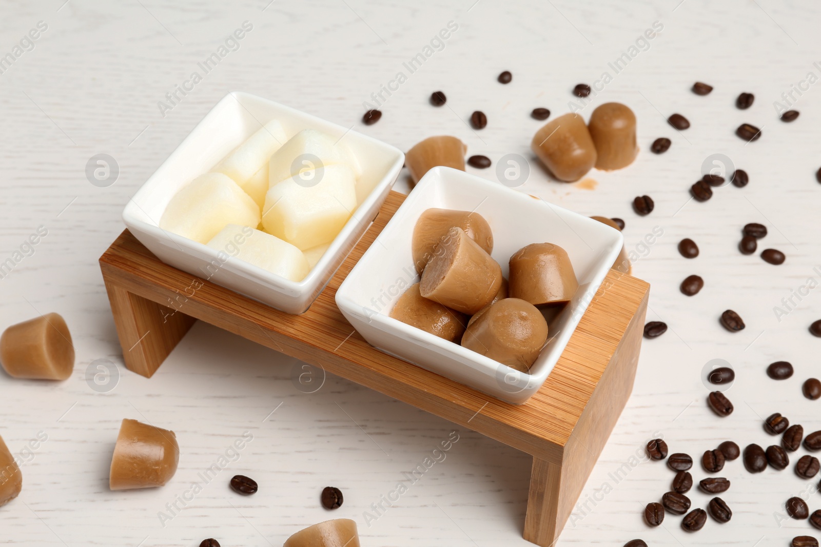 Photo of Composition with milk and coffee ice cubes on white wooden table