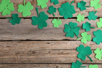 St. Patrick's day. Decorative clover leaves on wooden background, flat lay. Space for text