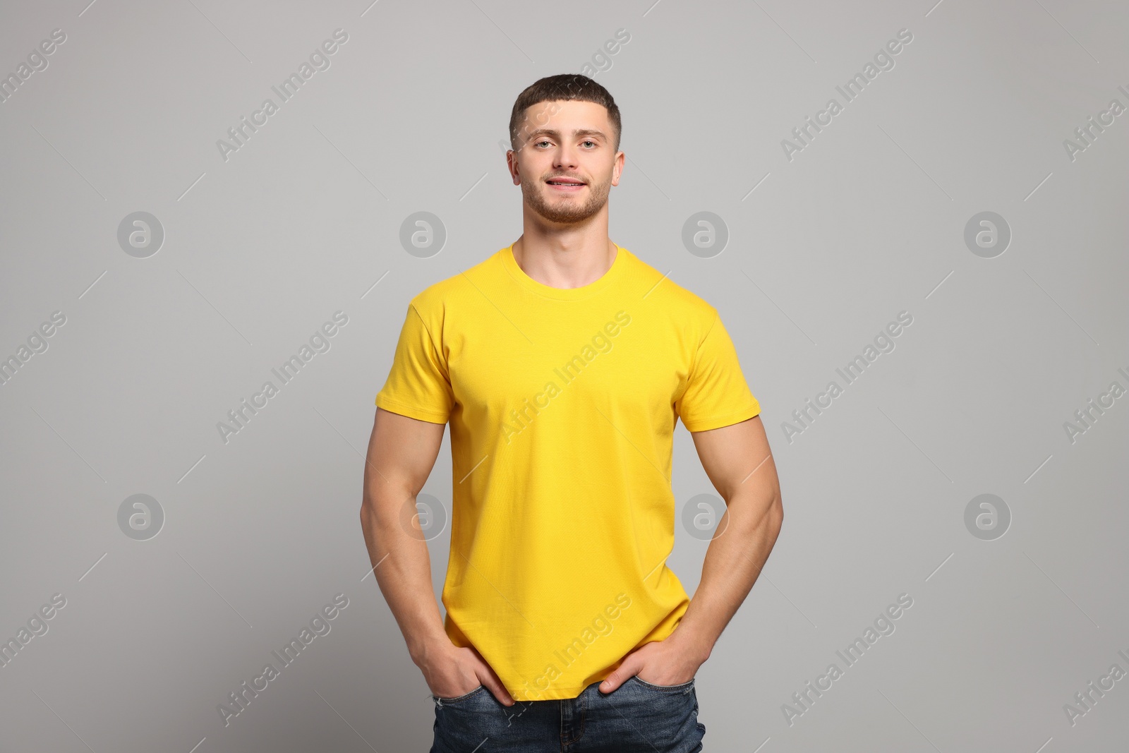 Photo of Man wearing yellow t-shirt on light grey background. Mockup for design