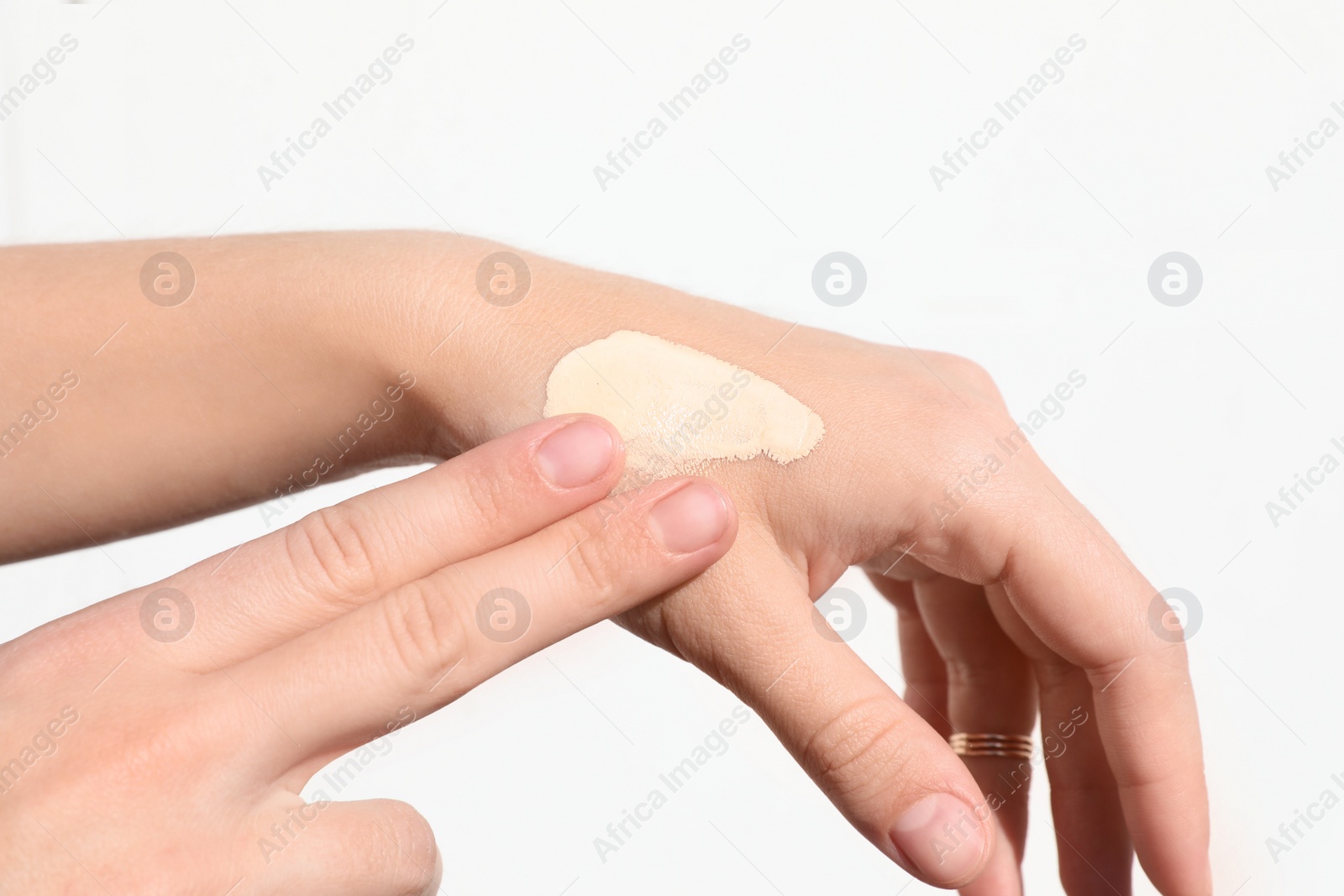 Photo of Woman testing foundation tone on hand, closeup