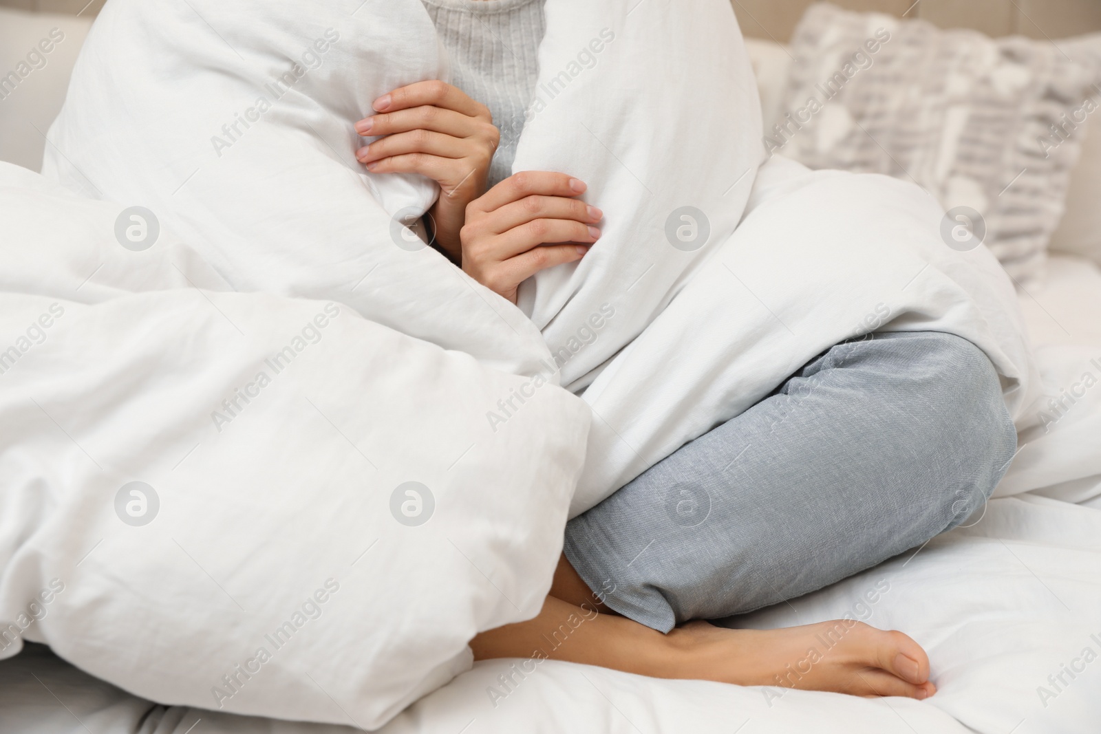 Photo of Woman with soft blanket sitting on bed, closeup