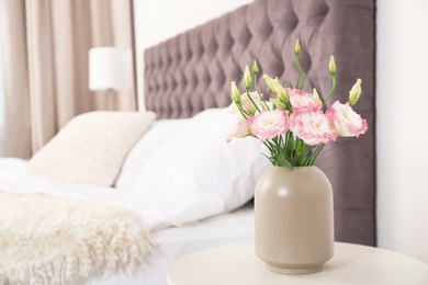 Photo of Beautiful flowers in vase and space for text on blurred background. Element of interior design