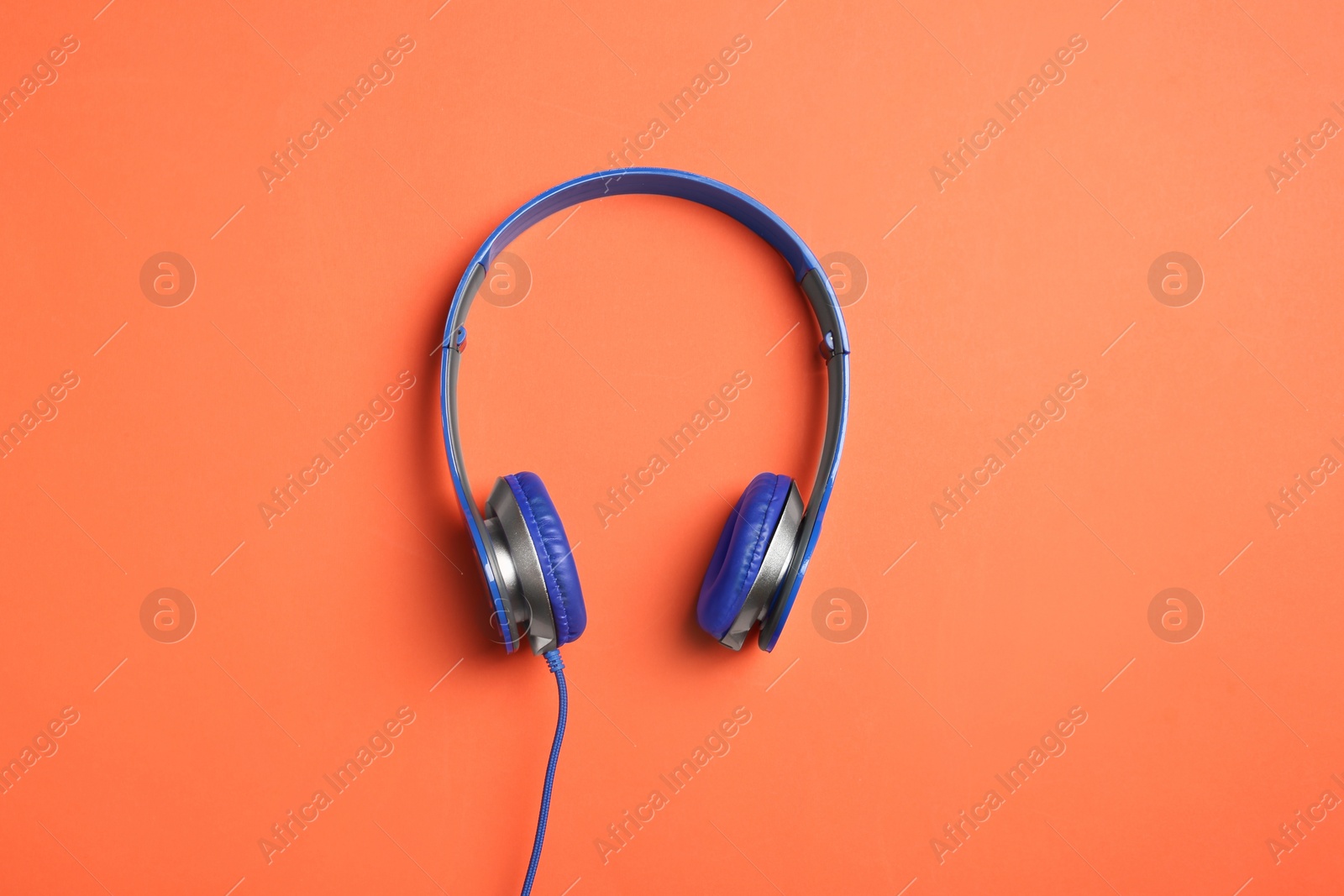 Photo of Stylish headphones on color background, top view