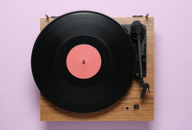 Modern turntable with vinyl record on light background, top view