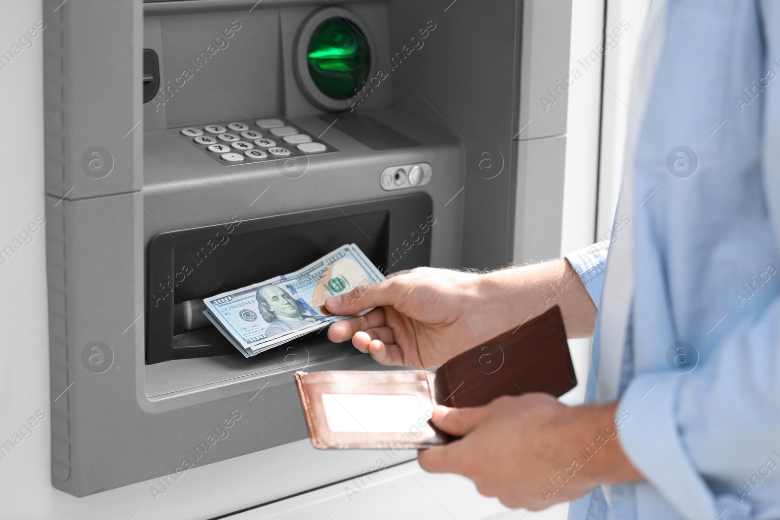 Photo of Man taking money from cash machine outdoors, closeup