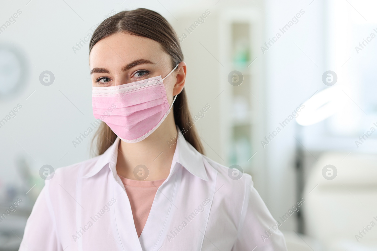 Photo of Cosmetologist in medical uniform in clinic, space for text