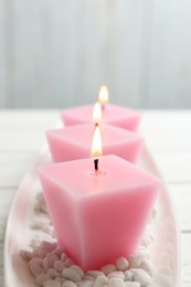 Photo of Composition with three burning candles on white table