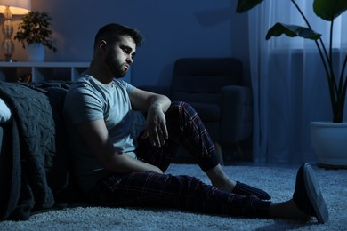 Photo of Man suffering from insomnia in bedroom at night