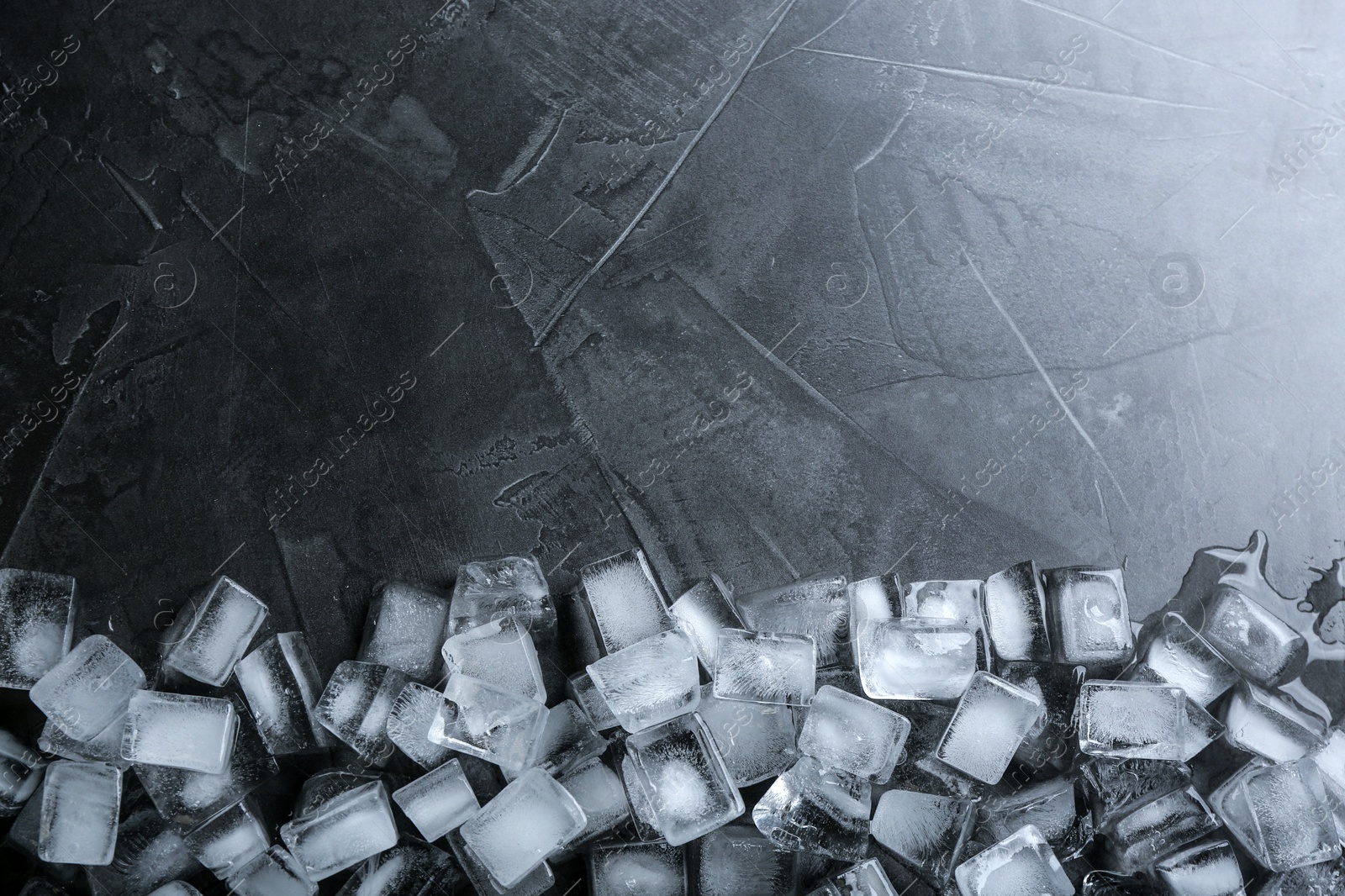 Photo of Ice cubes on grey table, flat lay. Space for text