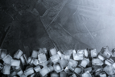 Photo of Ice cubes on grey table, flat lay. Space for text