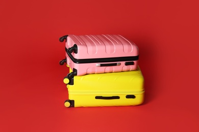 Photo of Stylish modern suitcases on color background. Traveler's baggage