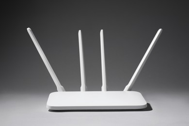 Photo of New stylish Wi-Fi router on grey background