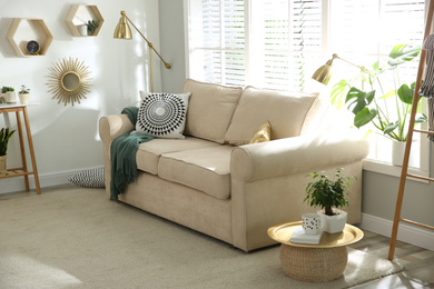 Photo of Stylish beige sofa in modern living room interior