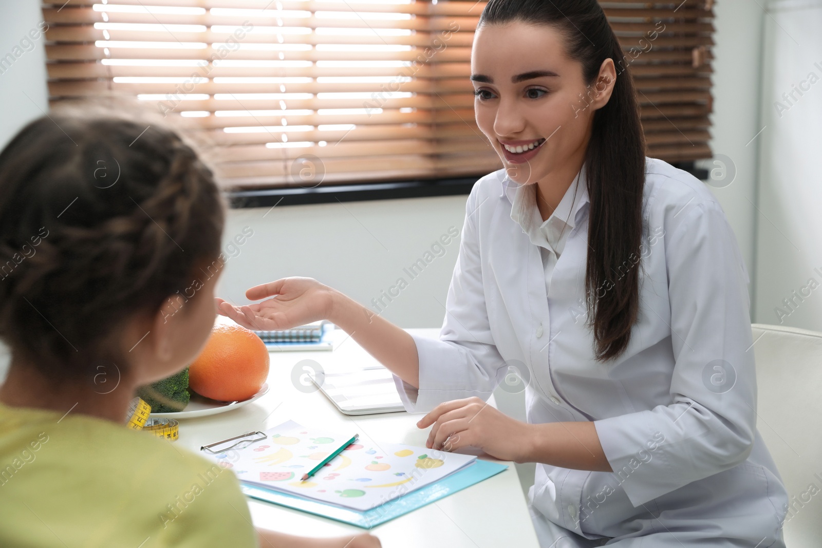 Photo of Little girl visiting professional nutritionist in office